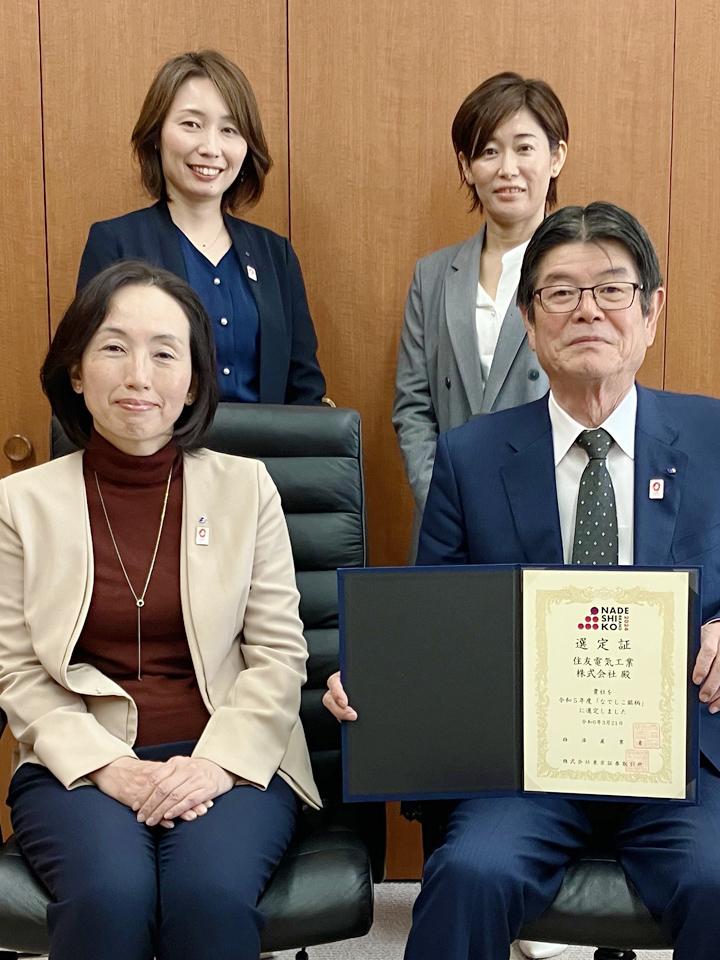 Holding the Nadeshiko Brand certificate, with Executive Officer Kunii (seated) and members of the Diversity and Inclusion Department.